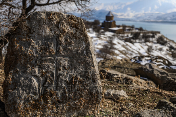 Akdamar Adası'ndaki haç kabartmalı tarihi mezar taşı, arka plandaki Akdamar Kilisesi ve Van Gölü ile eşsiz kültür mirası