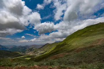 Dersim Buyer Dağı'nda yeşil dağlar ve bulutlu gökyüzü