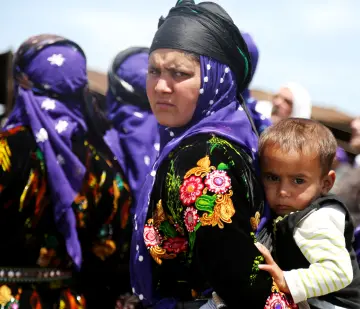 Her yıl geleneksel olarak Karacadağ eteklerinde düzenlenen hasat festivaline katılan sırtındaki heybesinde çocuğunu taşıyan genç kadının şaşkın bakışları.