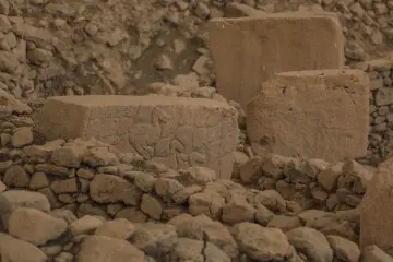 Göbeklitepe'de bulunan kabartmalı taş blok ve Neolitik hayvan figürlerinin yakın plan görünümü.