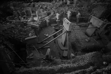 Göbeklitepe kazı alanının T biçimli dikili taşlarını gösteren siyah beyaz genel görünümü.