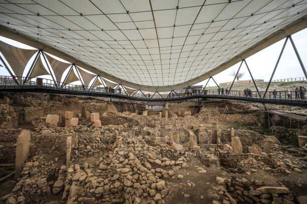 Göbeklitepe kazı alanının koruma çatısı altındaki panoramik görünümü ve Neolitik taş yapıların genel görünümü.