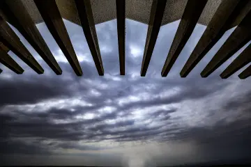 Göbeklitepe koruma yapısının mimari detayları ve dramatik bulutlu gökyüzünün perspektif görünümü.