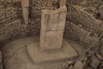 Göbeklitepe T biçimli dikilitaşının dairesel taş yapılar içindeki yakın plan görünümü.