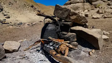 Hakkari yaylasında taşlarla çevrili ateş, siyah kazan ve geleneksel dağ yaşamından doğal bir sahne