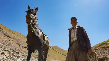 Hakkari yaylasında adam ve at, geleneksel yayla yaşamı ve dağlık arazi