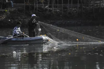 Hevsel Bahçeleri'nde Dicle Nehri üzerinde balık ağıyla balıkçılık yapan kişiler ve küçük tekne