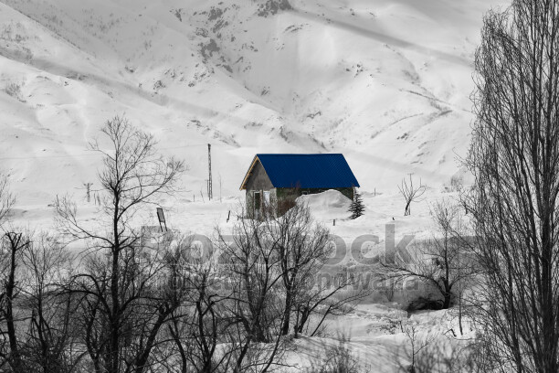 Karlı dağlar, mavi çatılı dağ evi ve kış manzarası