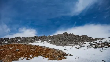 Karlı kayalık dağ zirvesi, yüksek rakım ve kış doğası manzarası