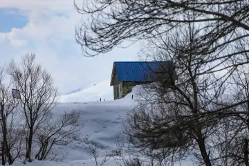 Karlı Munzur Dağları, mavi çatılı dağ evi ve kış manzarası