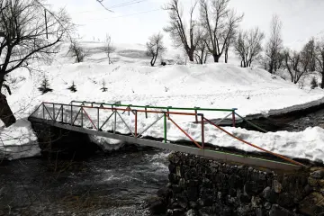 Karlı Munzur Gözeleri, dere üzerindeki küçük köprü ve kış manzarası
