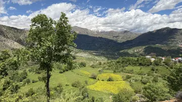 Peçar yüksek tepeden çekilen sarom çayı ve etraftaki dağ görünümü içinde köy evleri