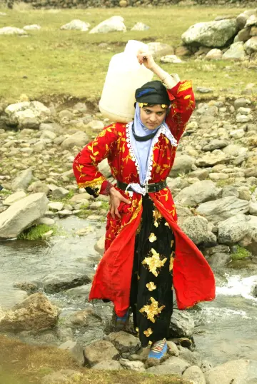 Siverek karacağ eteklerinde bulunan çıkrık köyünde yöresel elbise ile evine su taşıyan köylü genç kadın.