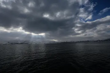 Van Gölü üzerinde bulutların arasından süzülen güneş ışınları, karla kaplı dağlar ve etkileyici kış manzarası sunuyor.