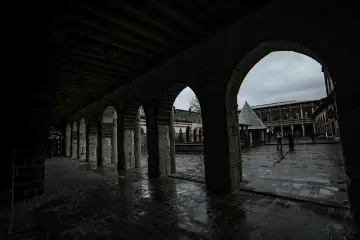 Yağmurlu tarihi han avlusu, taş kemerler ve geleneksel mimari
