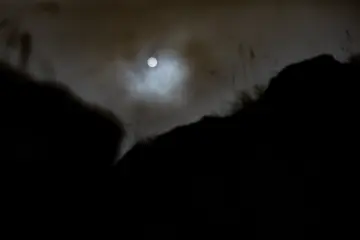 Zerzevan Kalesi üzerinde bulutlar arasındaki ay, Mezopotamya'nın tarihi dokusunda etkileyici gece manzarası.